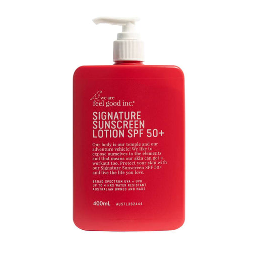 A 400mL red bottle of 'we are feel good inc.' Signature Sunscreen Lotion SPF 50+ with a white pump dispenser, shown on a solid white background.