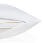 Close-up of a white pillow with a gold accent on a white background.  The Lad Collective bed linen from Shop Meriton Suites.