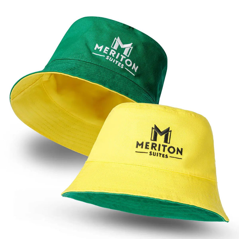 Two bucket hats, one green and one yellow, with 'Meriton Suites' logo on a white background. Shop Meriton Suites.