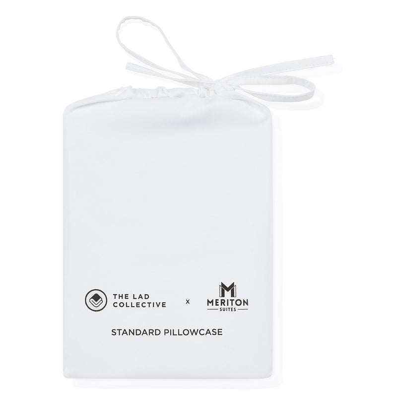 White pillowcase with 'The Lad Collective' and 'Meriton Suites' logos on a white background.  The Lad Collective bed linen from Shop Meriton Suites.