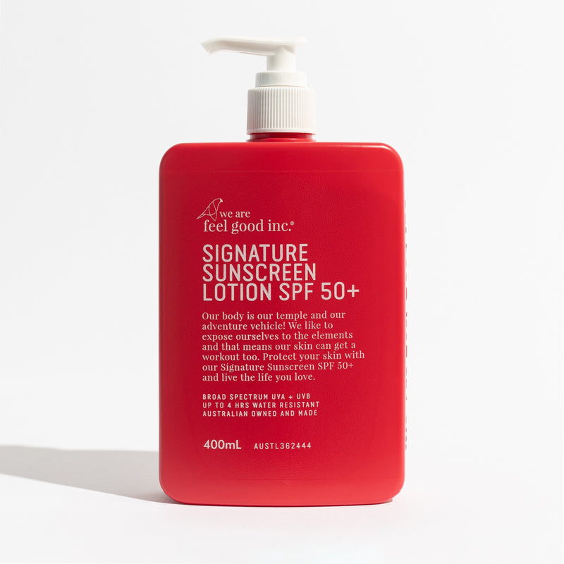 A 400ml red pump bottle of 'we are feel good inc.' Signature Sunscreen Lotion SPF 50+ on a clean white background. Shop Meriton Suites. We are feel good inc. spf sunscreen.