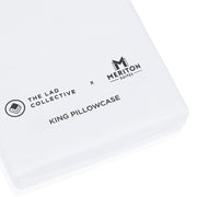 White king pillowcase with 'The Lad Collective' and 'Meriton Suites' logos on a white background.  The Lad Collective bed linen from Shop Meriton Suites.