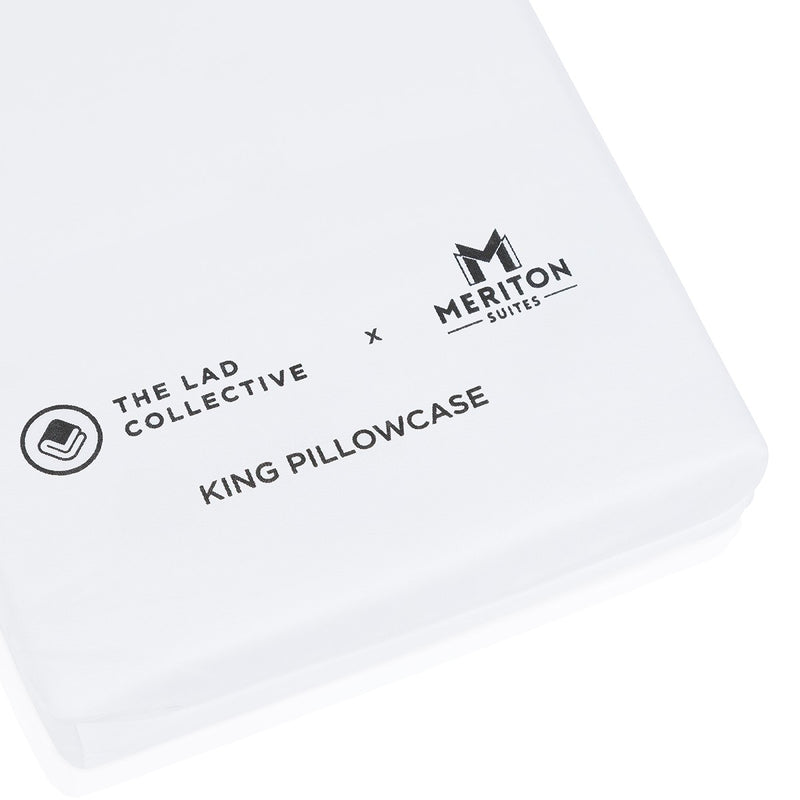 White king pillowcase with 'The Lad Collective' and 'Meriton Suites' logos on a white background.  The Lad Collective bed linen from Shop Meriton Suites.
