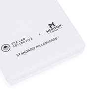 White pillowcase with 'Meriton Suites' and 'The Lad Collective' branding on a white background