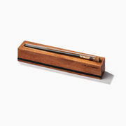 Wooden pencil holder with a pen inside on a white background